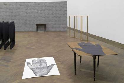 Lucy Skaer The Siege 2008 print of a had on paper placed on the floor a table with the same large handprint printed directly on to it
