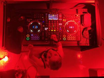 A photograph taken from above of someone at a DJ deck.