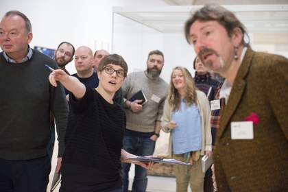 A group of teachers looking towards an artwork
