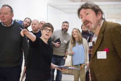 A group of teachers looking towards an artwork