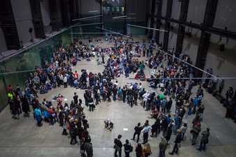 A crowd form four rough circles and dispurse in places in the Turbine Hall