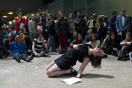 Female dancer wearing black kneeling on the floor and falling back