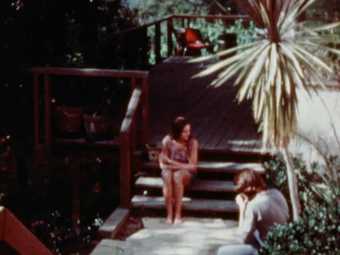 A woman and a man sit near the entrance of a California home