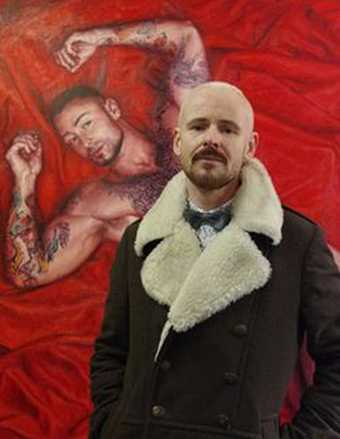 A man stands in front of an artwork showing a man lying on a red cloth