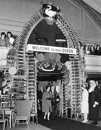 Queen Elizabeth II entering High Wycombe Town Hall through an archway made of locally made chairs, April 1962