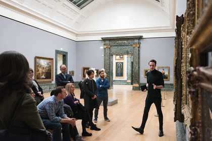 Group gather in front of a painting