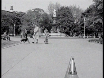 A park with a child riding a tricycle