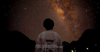 The back of a person in a space suit looking up at a dark but starry sky.