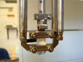 A paint film being tested in a Dynamic Mechanical Analyser, which can measure mechanical properties during immersion in liquids 