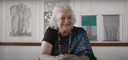 Photograph of Monika Correa sitting at a table looking towards the camera