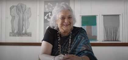 Photograph of Monika Correa sitting at a table looking towards the camera