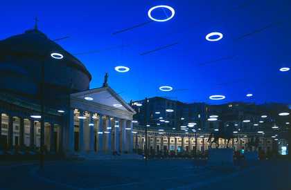 Colour photograph of an exterior building with circular lights above it in the sky