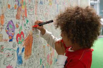Six year old Jude drawing on cartoon drawings in the Moshi Monsters studio London
