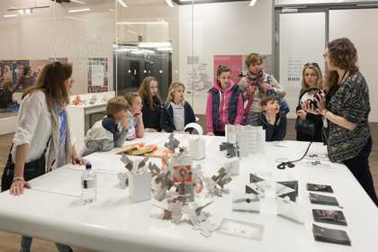 People standing around a table looking at objects
