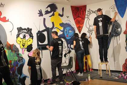 People painting graffiti on the wall