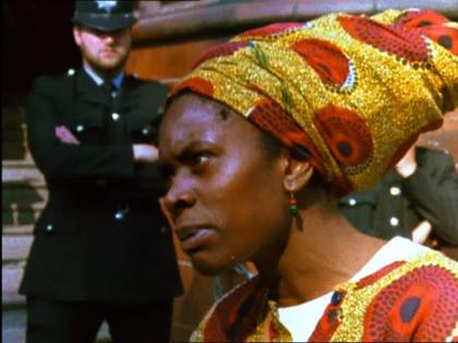 Film still of an woman wearing an African headscarf