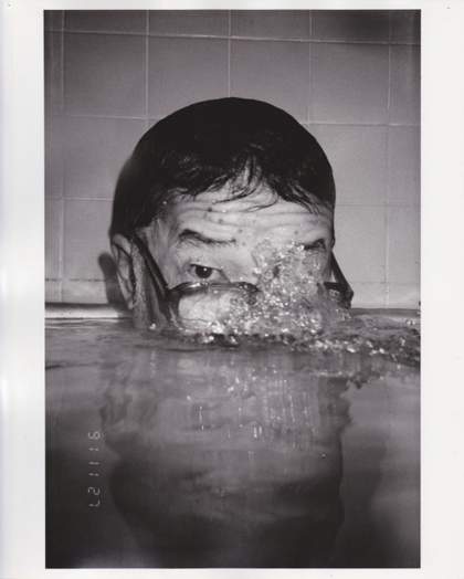 Photograph Masahisa Fukase Bukubuku (bubbling) 1991 showing a man in a bath or swimming pool blowing bubbles