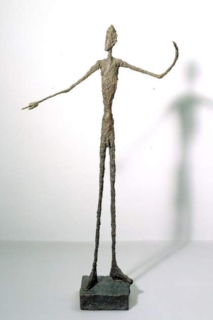 Standing wire figure by Alberto Giacometti with a shadow behind it