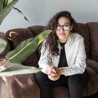 Nadira Amrani sitting on a couch