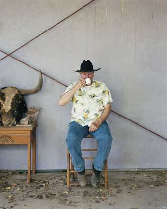 Bruce Nauman sits on a chair in his home and sips a coffee