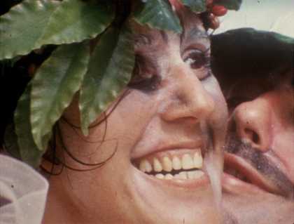 a woman with leaves on a head smiles