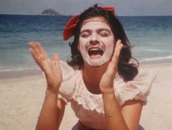 a woman with a face mask looks like she is laughing or screaming on a beach