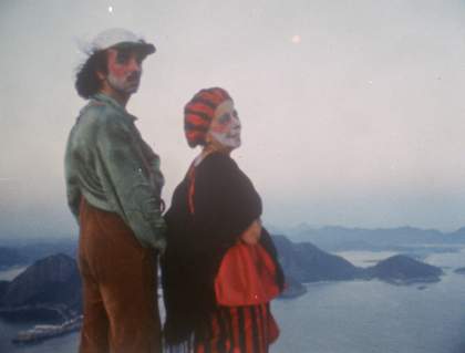 a couple stand in front of a sea landscape