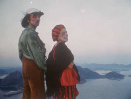 a couple stand in front of a sea landscape