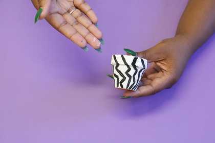 Photograph of a two hands holding a small plant pot