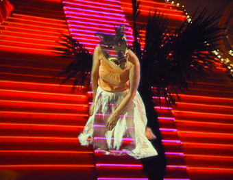 film still of person with animal mask on against stairs
