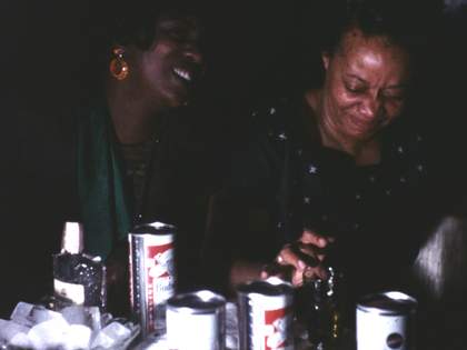 darkly lit photograph of two people sitting at a table