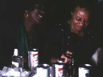 darkly lit photograph of two people sitting at a table