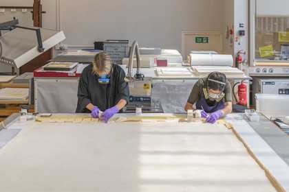Photograph of people checking paper