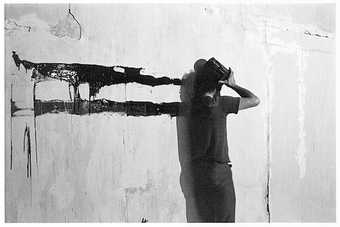 Paul McCarthy Face Head Shoulder Painting Wall Black Line 1972 photograph of a man dragging paint across a wall with his head face and shoulder