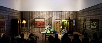 Performance shot of two people in a dining room space with lots of art on the wall