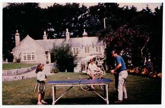 Peter Lanyon and daughter Anna Mary playing table tennis, with son Matthew on bicycle, at Little Park Owles, Carbis Bay c.1960