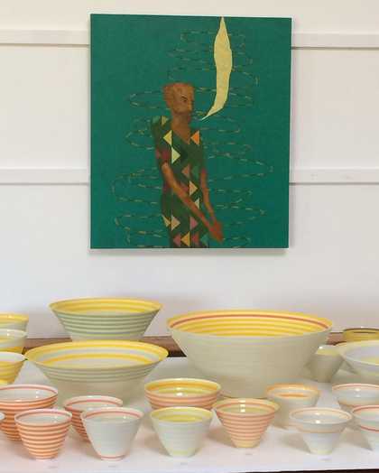 Photograph of bowls on a desk with a painting on the