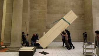 Art handlers installing plinth