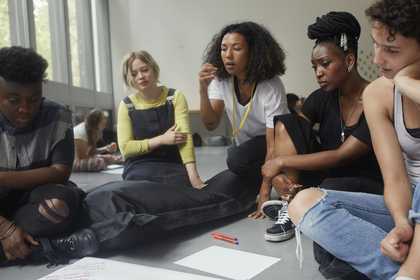 A group of young people sitting on a floor