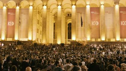 A crowd of thousands in front of the Georgian parliament at night