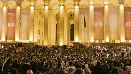 A crowd of thousands in front of the Georgian parliament at night