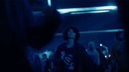 a blue-hued image of young people in a nightclub