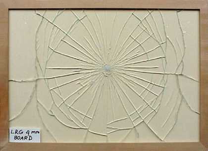 Regular breakage pattern of standard low reflective glass fitted in frame against a solid sheet of mount board