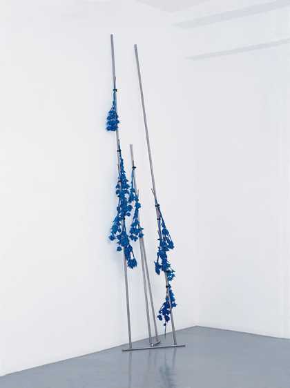 Roger Hiorns Discipline 2002 metal rods leaning against the gallery walls with blue flowers attached  