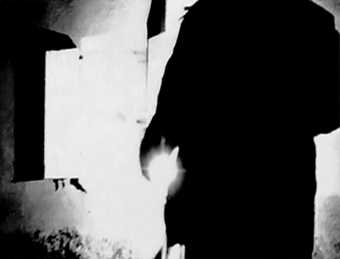 Black and white image of a close up or someone's torso in a lit room