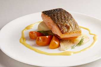 Salmon dish with tomatoes and oil on a plate