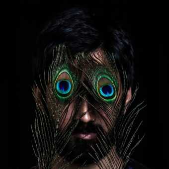 Musician Sarathy Korwar with peacock feathers over his eyes