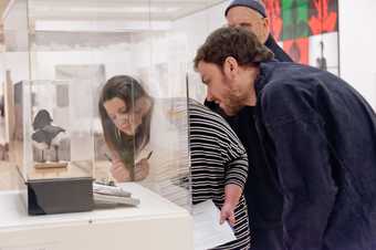 Two teachers looking into a vitrine with a sculpture in it
