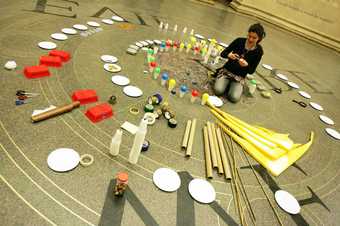 A teacher lays out art materials on the floor of Tate Britain