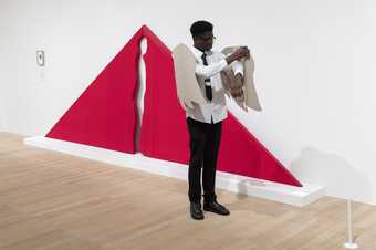 Student standing in front of a red artwork